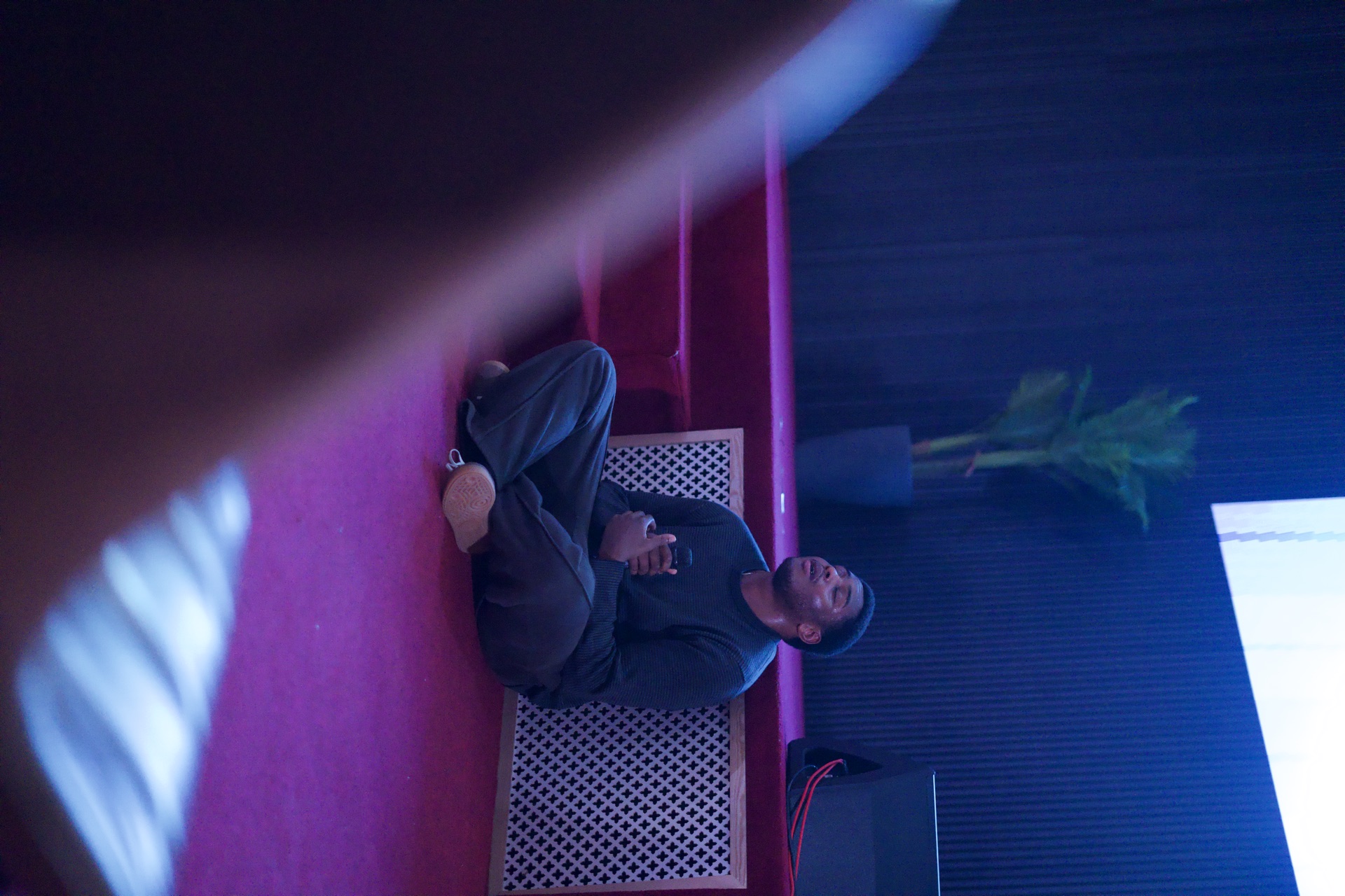 Man cross-legged on floor holding mic in worship