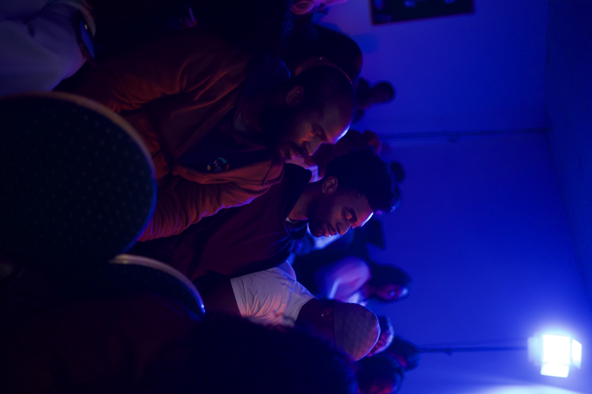 A speaker addressing the seated congregation under spotlight