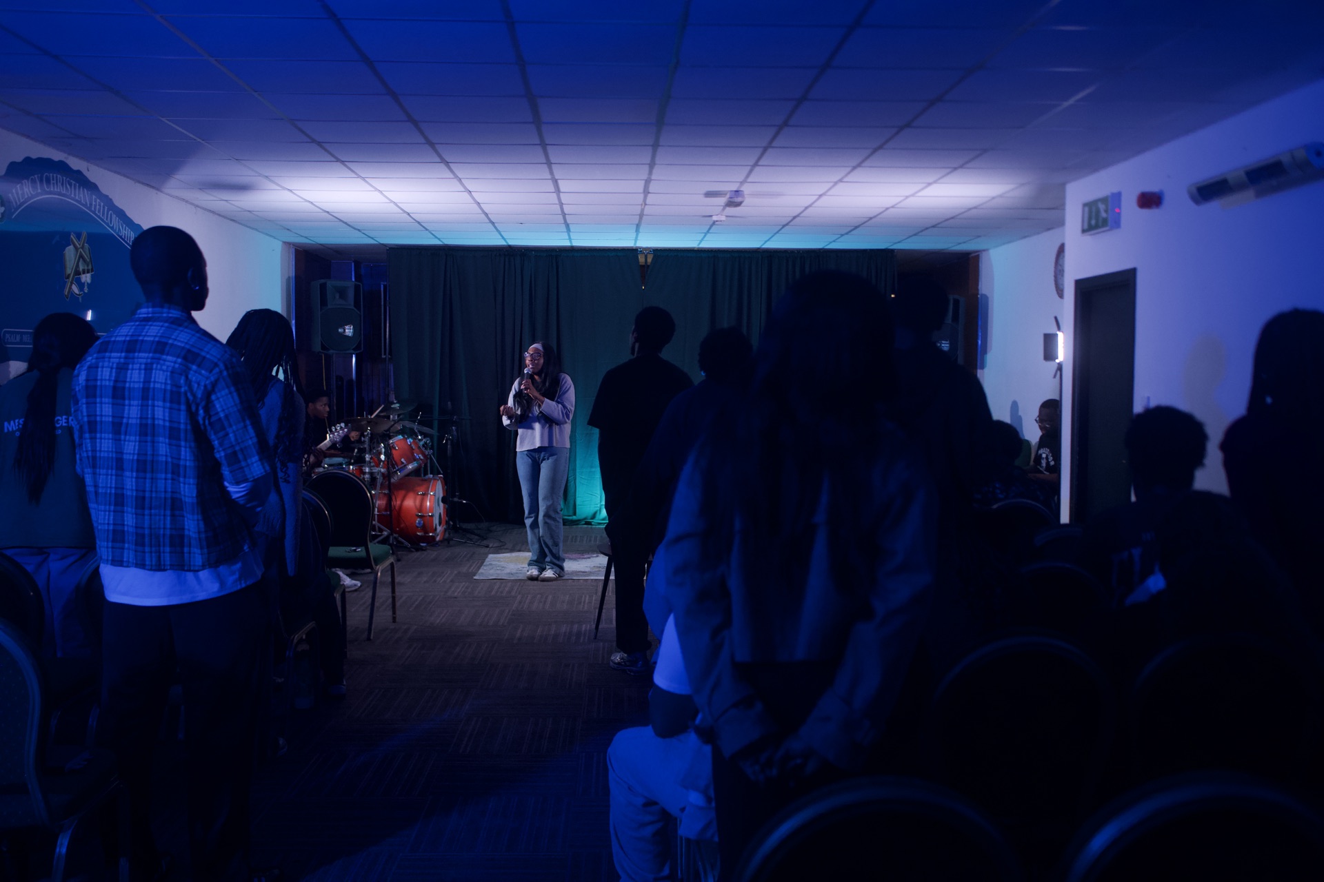 Woman ministering, laying hands, in purple and red light
